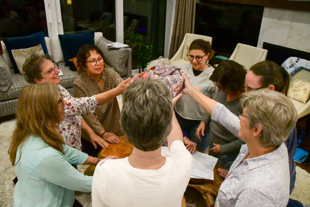 Group members holding the woven bowl together during a psychometry session